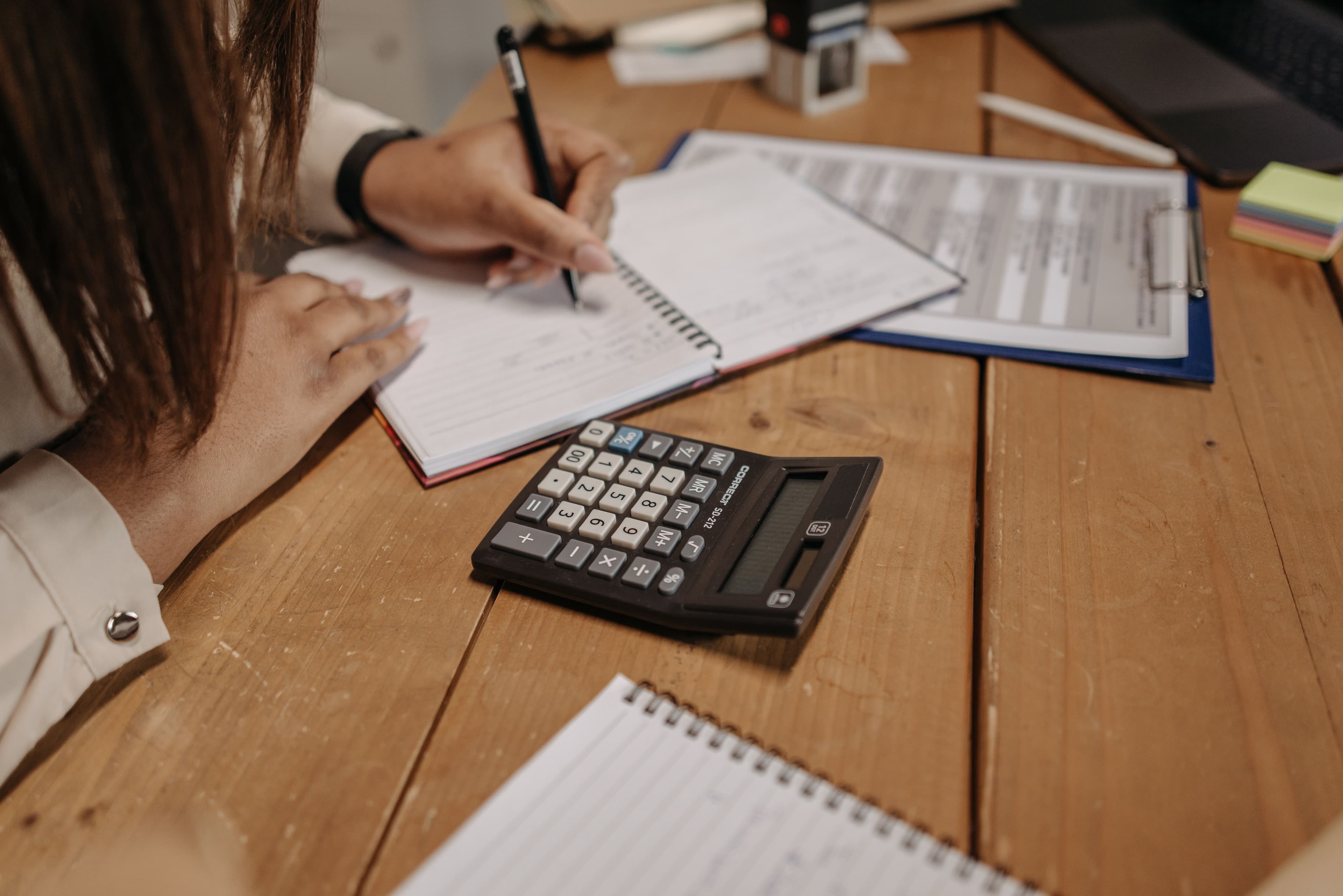 Persona calculando con calculadora y libreta